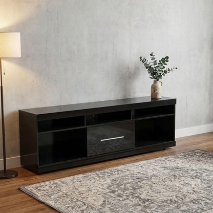 Modern Home black media console with open shelving and a central cabinet, set against a concrete wall in a living room.