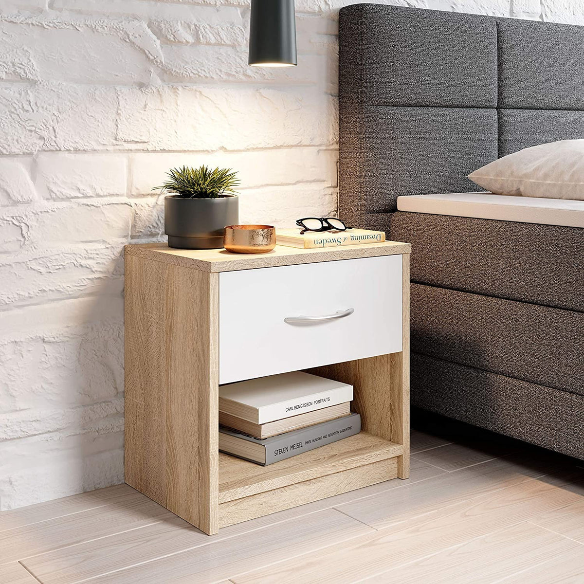 Modern Home light oak bedside table with a white drawer, aluminum handle, and open storage shelf in a bedroom.