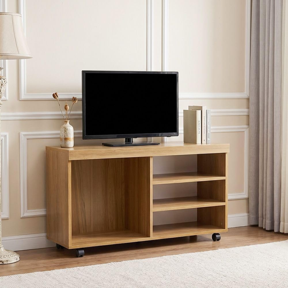 Modern Home rolling media console in natural wood finish with open shelving and a television in a living room setting.