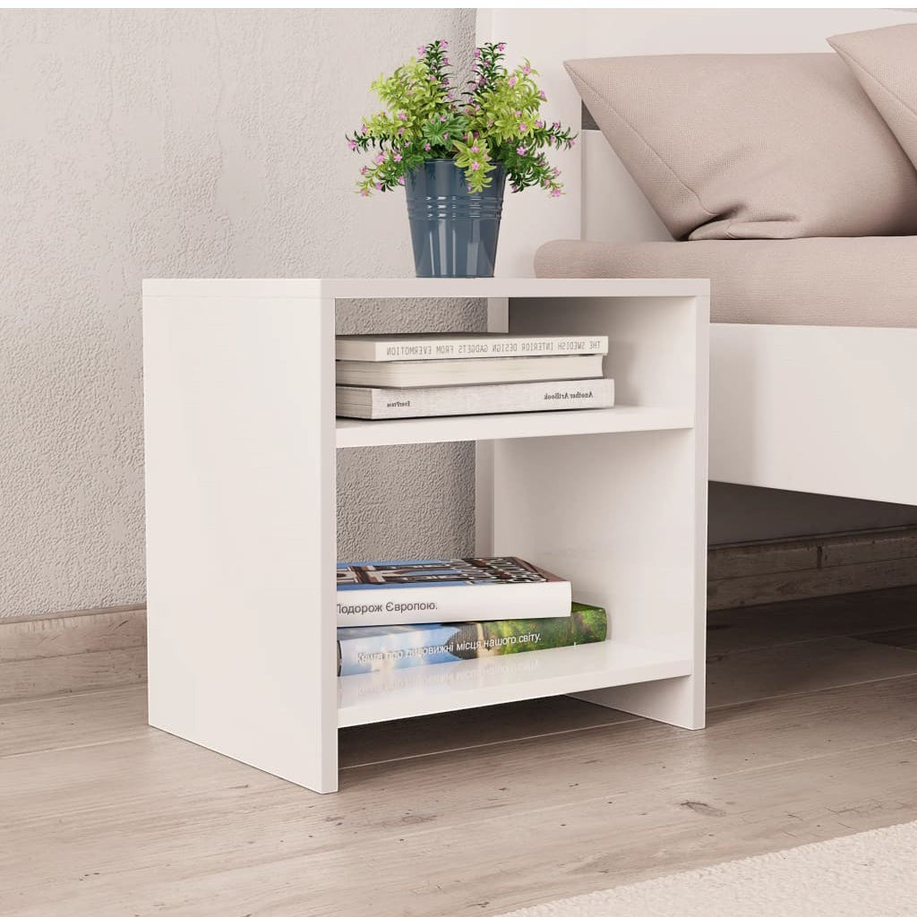 Modern Home white bedside table with two open shelves, holding books and a small potted plant next to a bed.